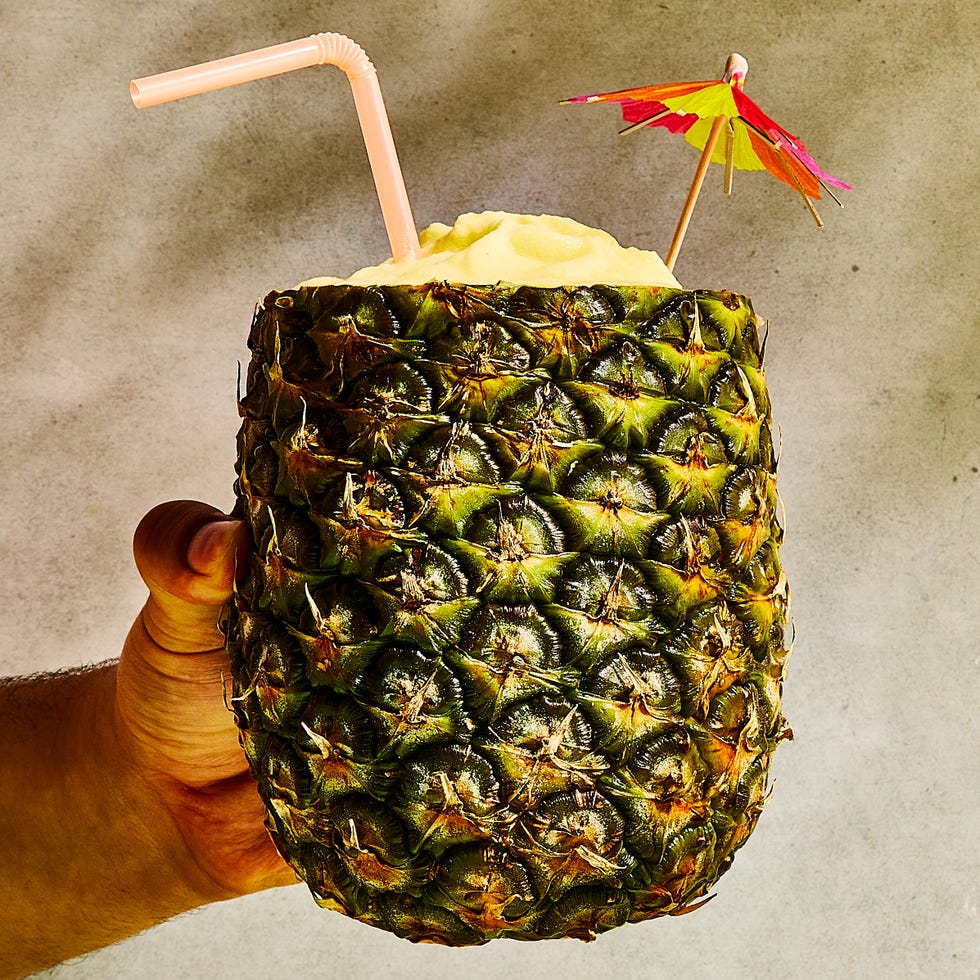 pineapple pina coladas in a pineapple with umbrellas