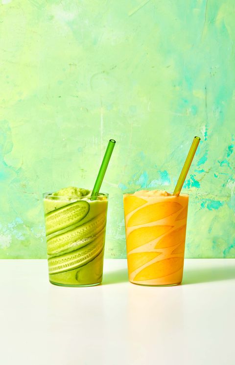 a light green pineapple cucumber smoothie and a pretty orange mango smoothie, made with fresh fruit, side by side with colorful glass straws, a healthy sweet snack