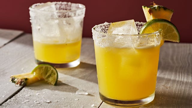 a glass of orange juice next to a lemon slice and a slice of lemon