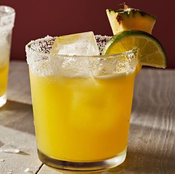 a glass of orange juice next to a lemon slice and a slice of lemon
