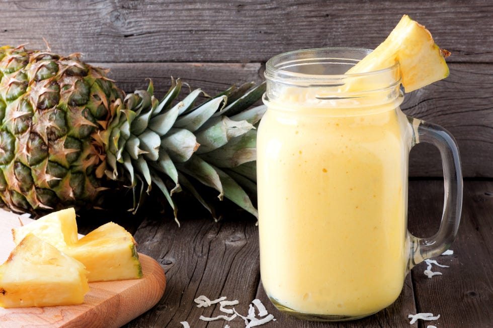 pineapple smoothie in a mason jar, scene against wood