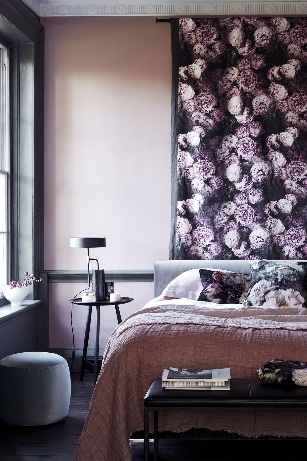 a bed with a flowered wallpaper