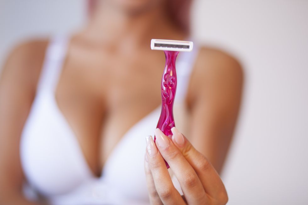 pink hair attractive woman hold pink female shaver in hand