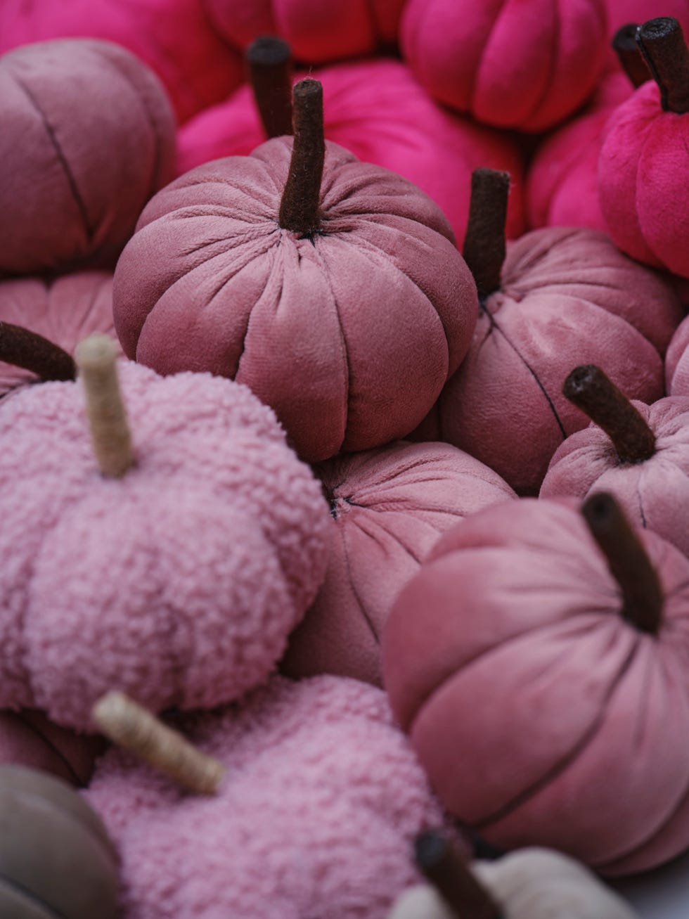 a collection of fabric pumpkins in soft textures showcasing different shades of pink from light to darker tones