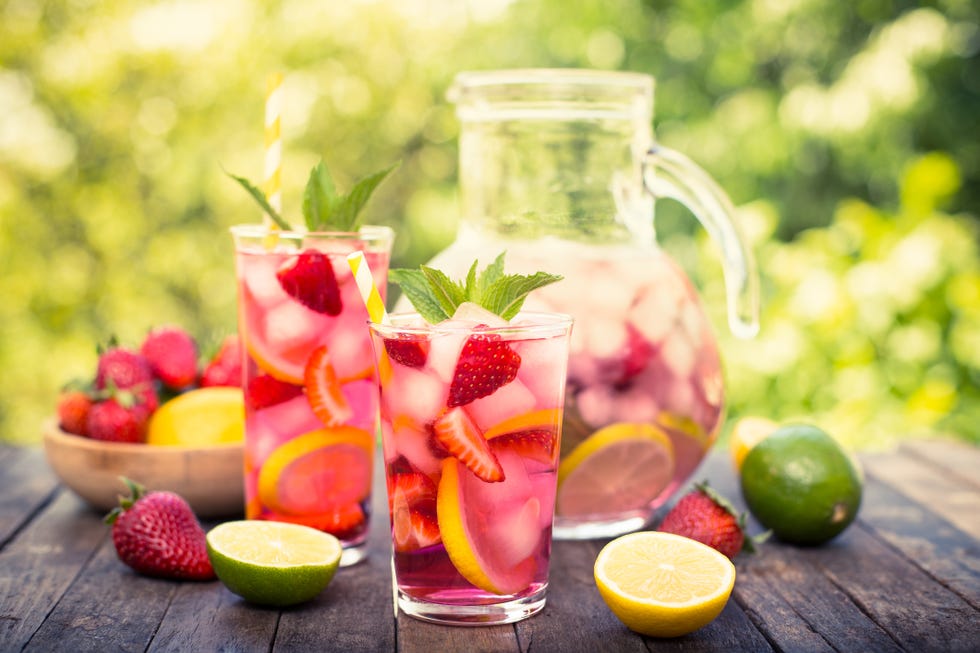 summer activities pink lemonade with lemon, lime and strawberries