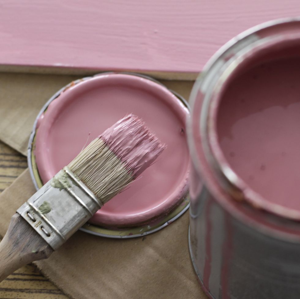 pink paint can with brush on pink background