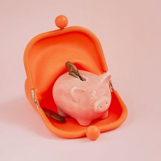 pink piggy piggy bank in an orange purse, concept of accumulation, saving money
