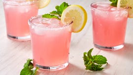 pink cocktail garnished with mint and a lemon wheel