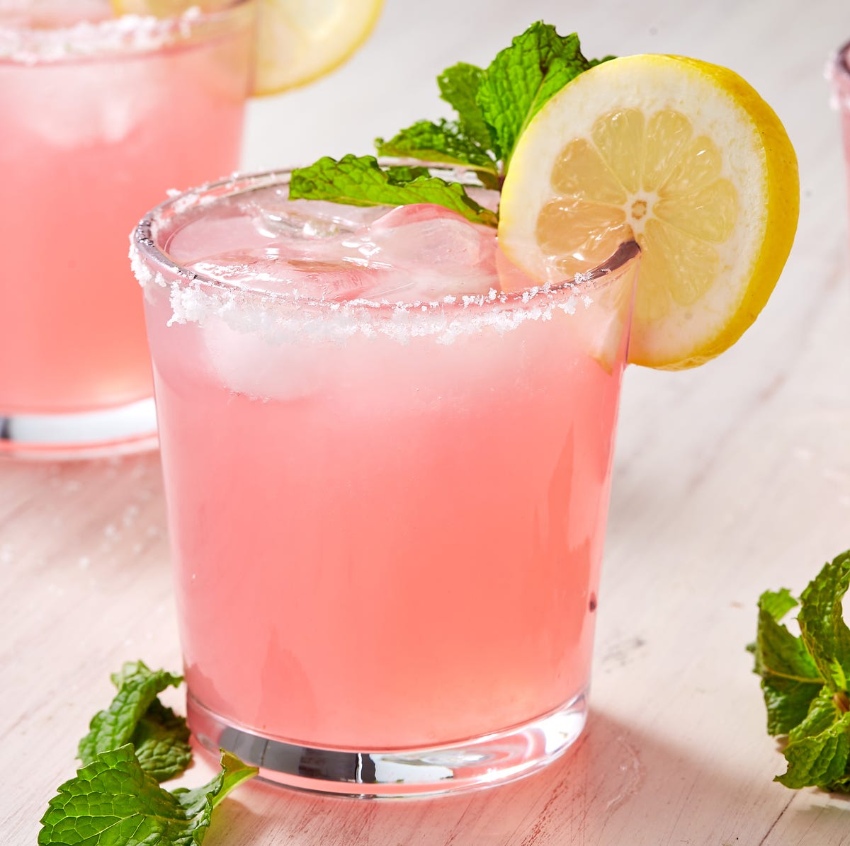 Pink Senoritas pink cocktail garnished with mint and a lemon wheel