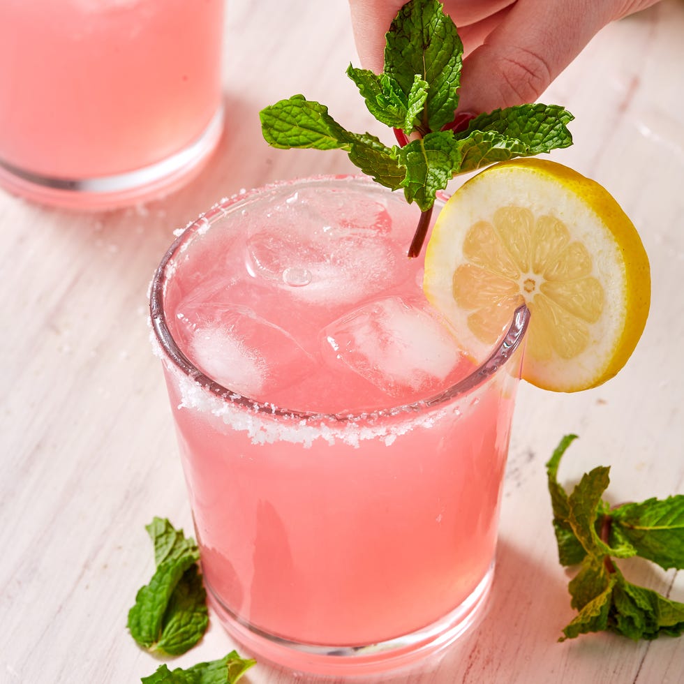 pink cocktail garnished with mint and a lemon wheel