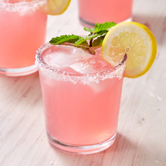 pink cocktail garnished with mint and a lemon wheel