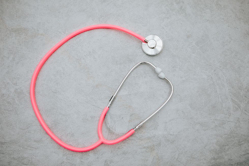 pink stetoscope in grey background