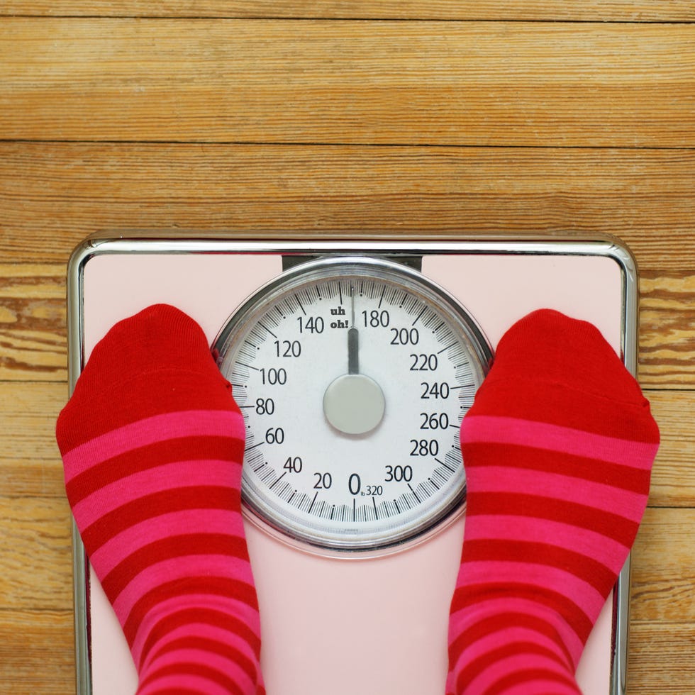 Pink striped socks standing on pink scale Pink striped socks standing on pink scale