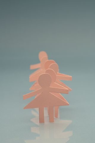 Pink woman paper chain dolls on blue background