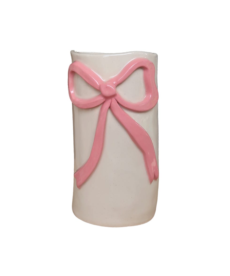 white vase with ceramic pink bow