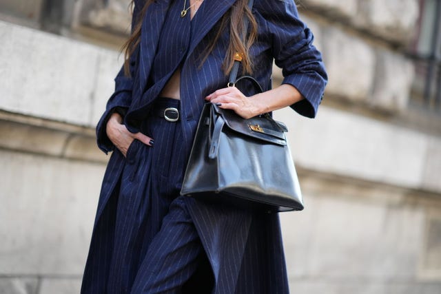 paris, france september 30 a guest wears a blue striped outfit and a black leather hermes bag, outside hermes, during the womenswear springsummer 2024 as part of paris fashion week on september 30, 2023 in paris, france photo by edward berthelotgetty images
