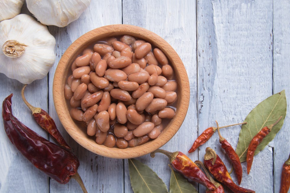 cooked pinto beans in a wooden bowl