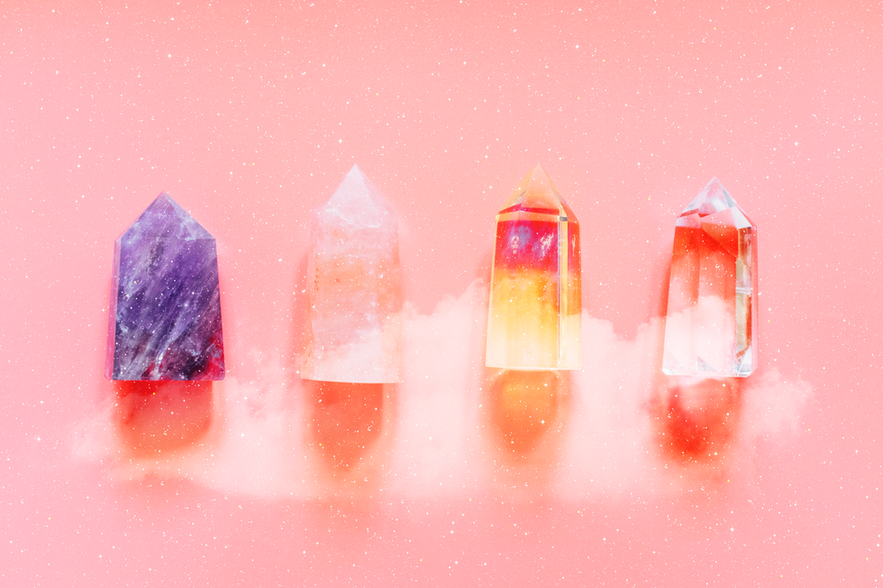 crystals of various colors lie next to each other on a pink background