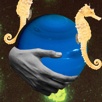 a man's hand holds the planet neptune with seahorses around it