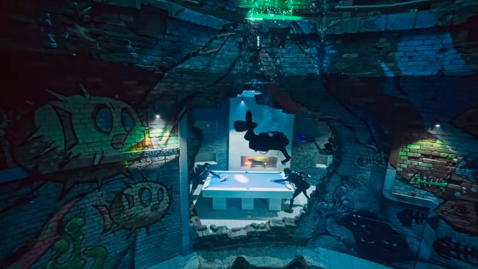 buzo explorando la ciudad sumergida de la piscina más profunda del mundo en dubai