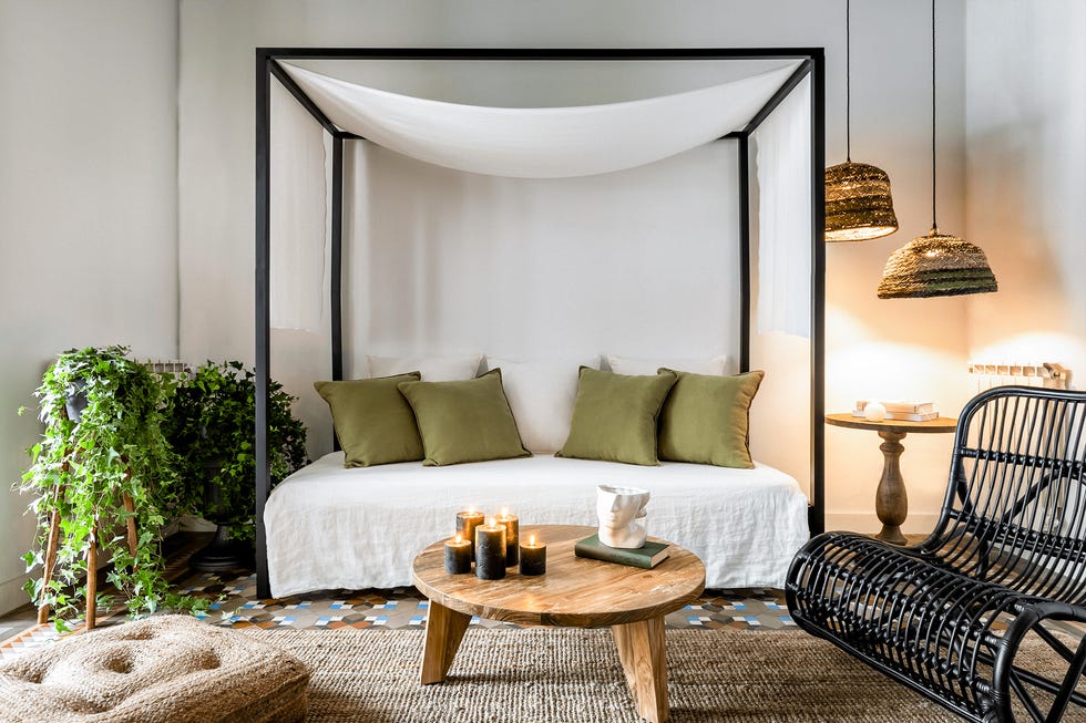 salón de estilo mediterráneo con sofá con dosel y mecedora de ratán negro