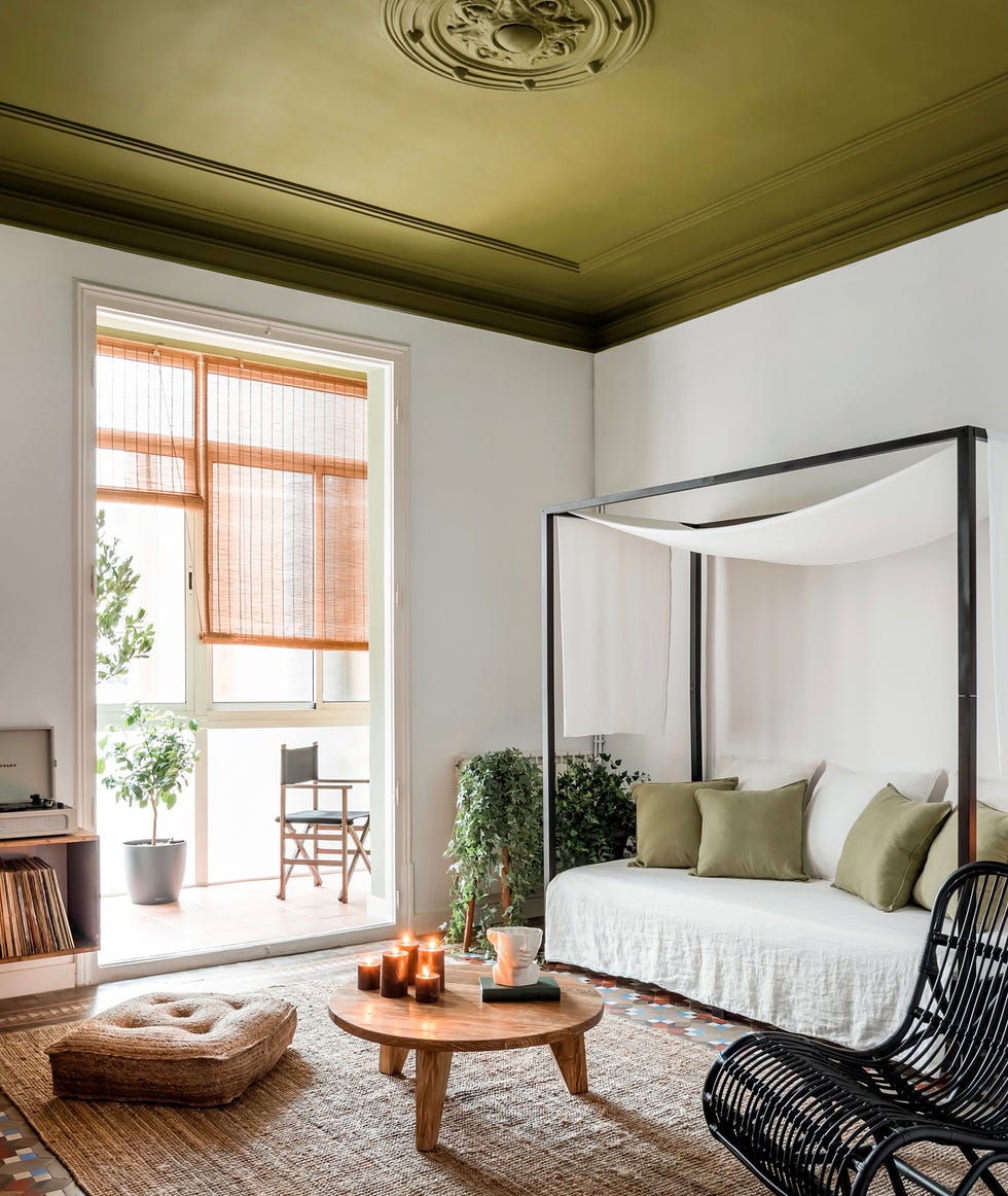 salón de estilo mediterráneo con sofá con dosel y mecedora de ratán negro