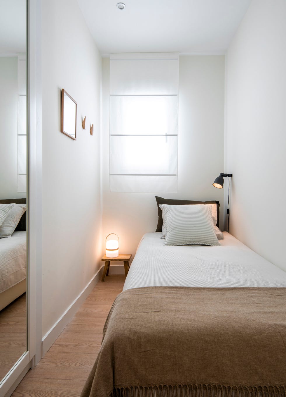 dormitorio con cama individual y taburete de madera como mesita de noche