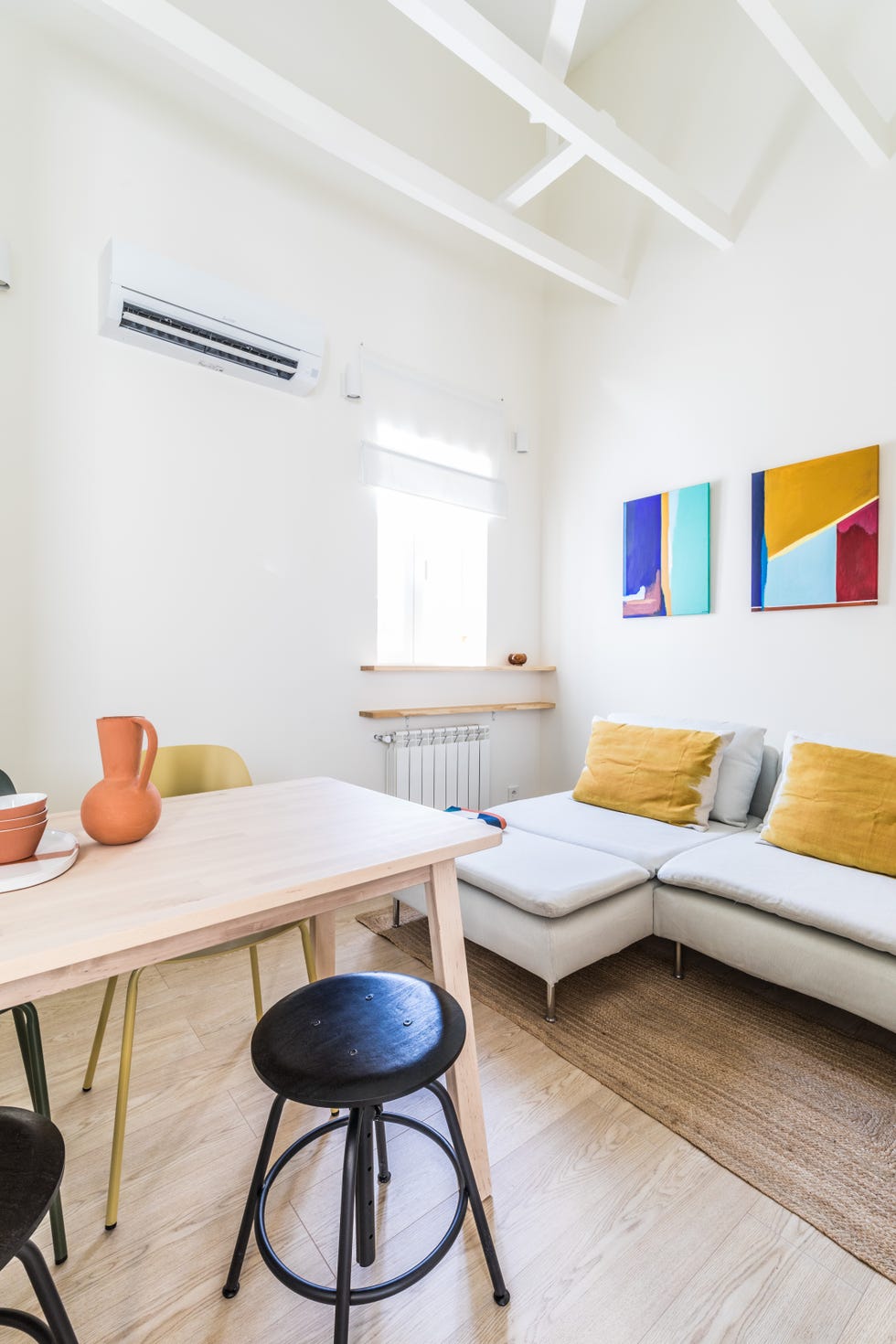 salón comedor con sofá modular y mesa de madera clara