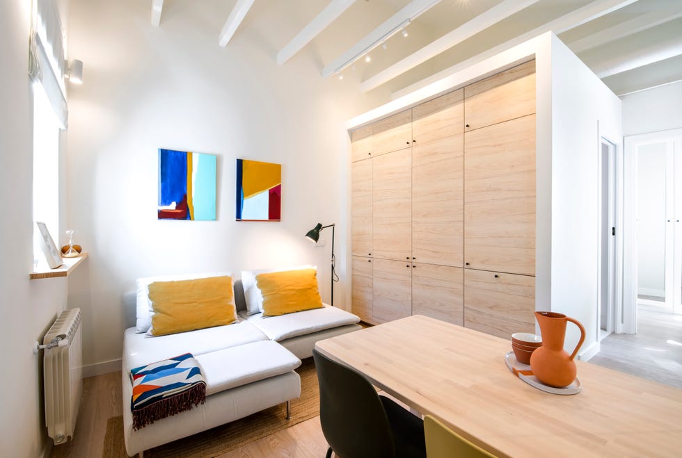 salón moderno con sofá modular y armarios empotrados de madera clara