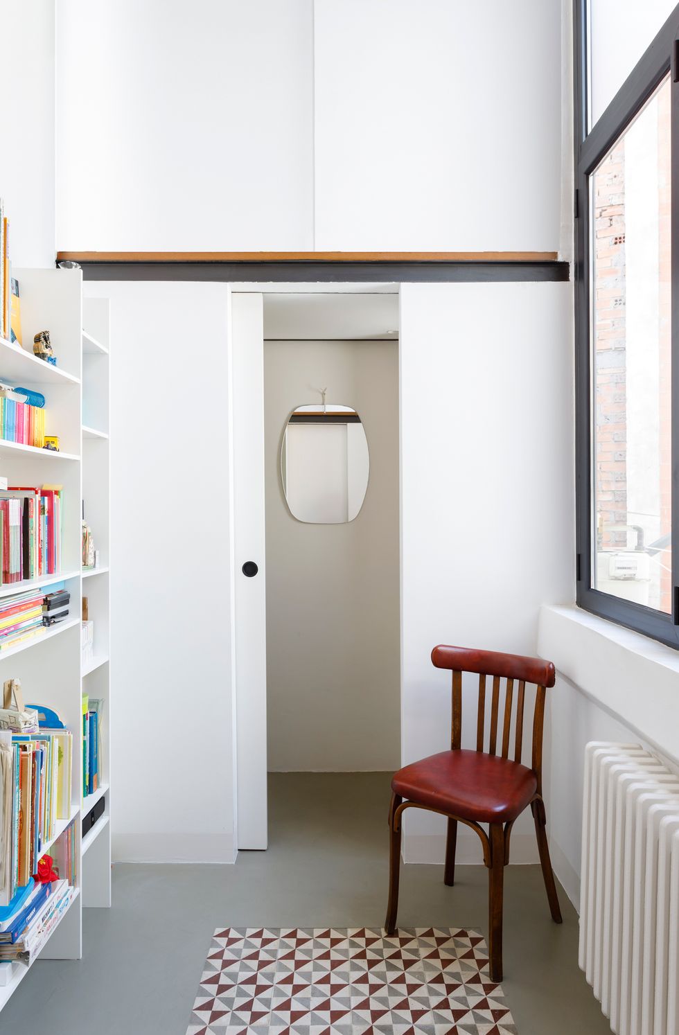 sala con librería blanca abierta y baldosas hidráulicas decorativas