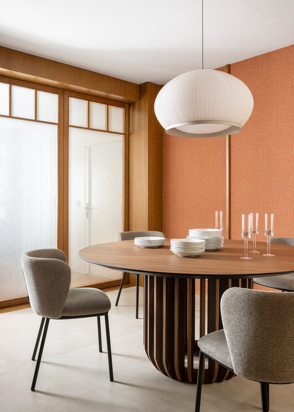 mesa de comedor de madera redonda con sillas tapizadas en gris