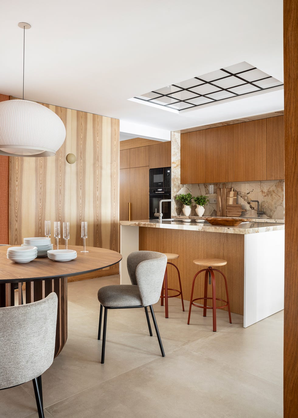 cocina con isla central y mesa de comedor de madera redonda