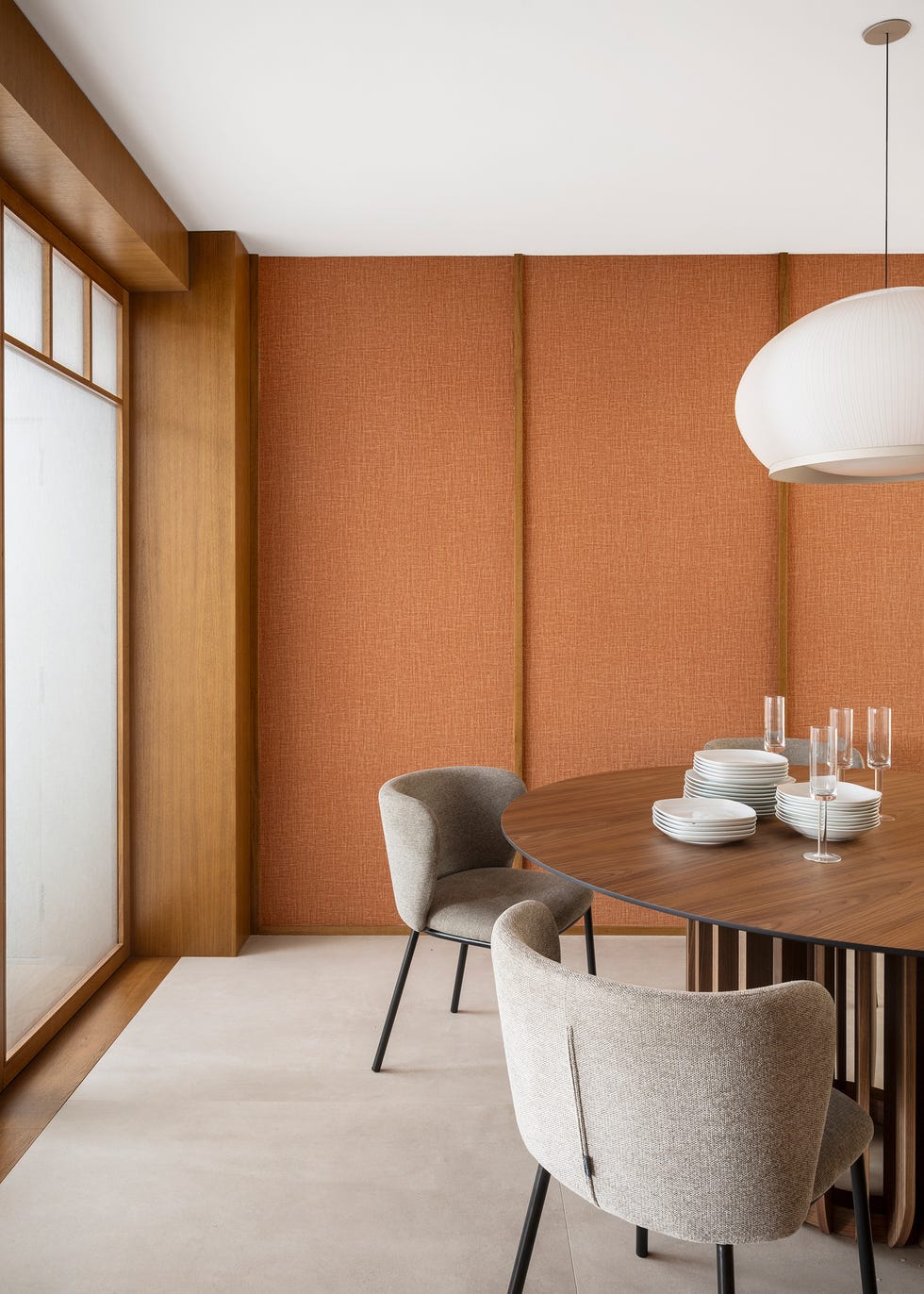 mesa de comedor de madera redonda con sillas tapizadas en gris
