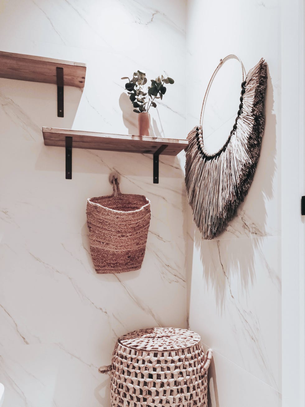 baño revestido con mármol y estantes de madera