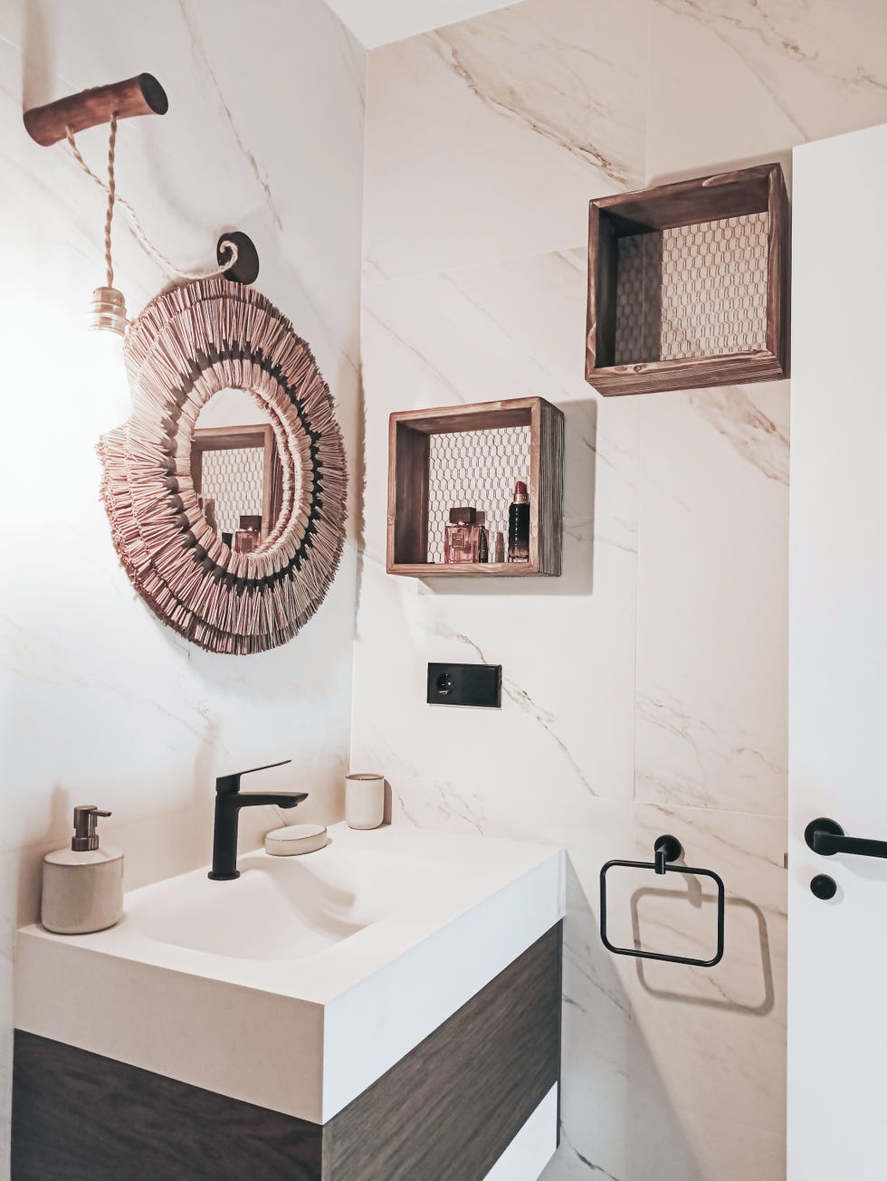 baño revestido con mármol y espejo redondo de fibras