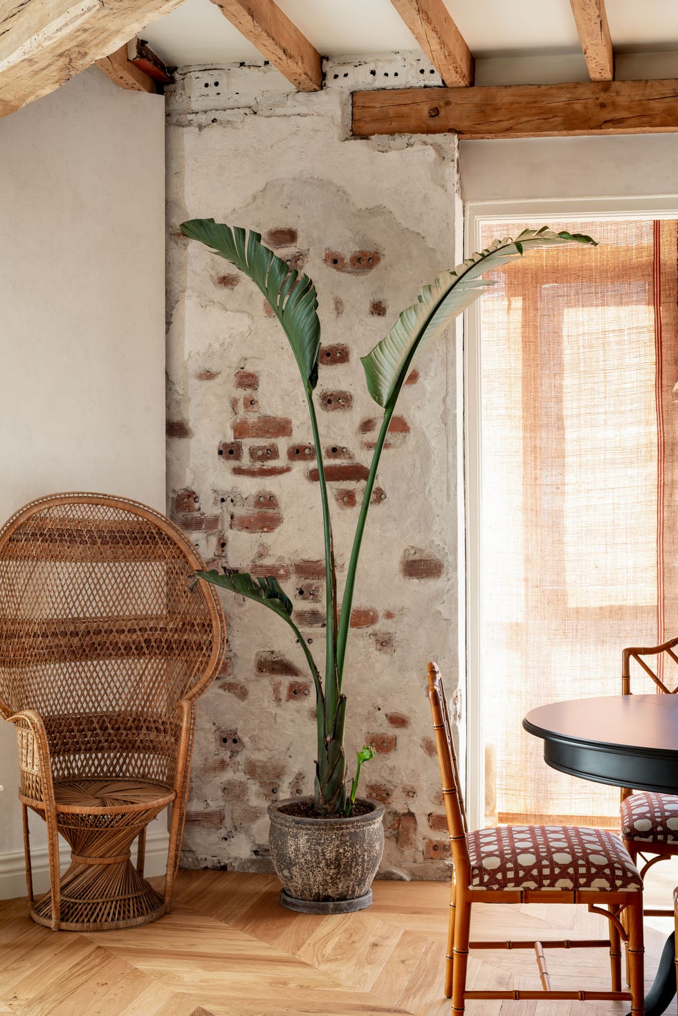 comedor con vigas vistas de madera, paredes de piedra y muebles vintage