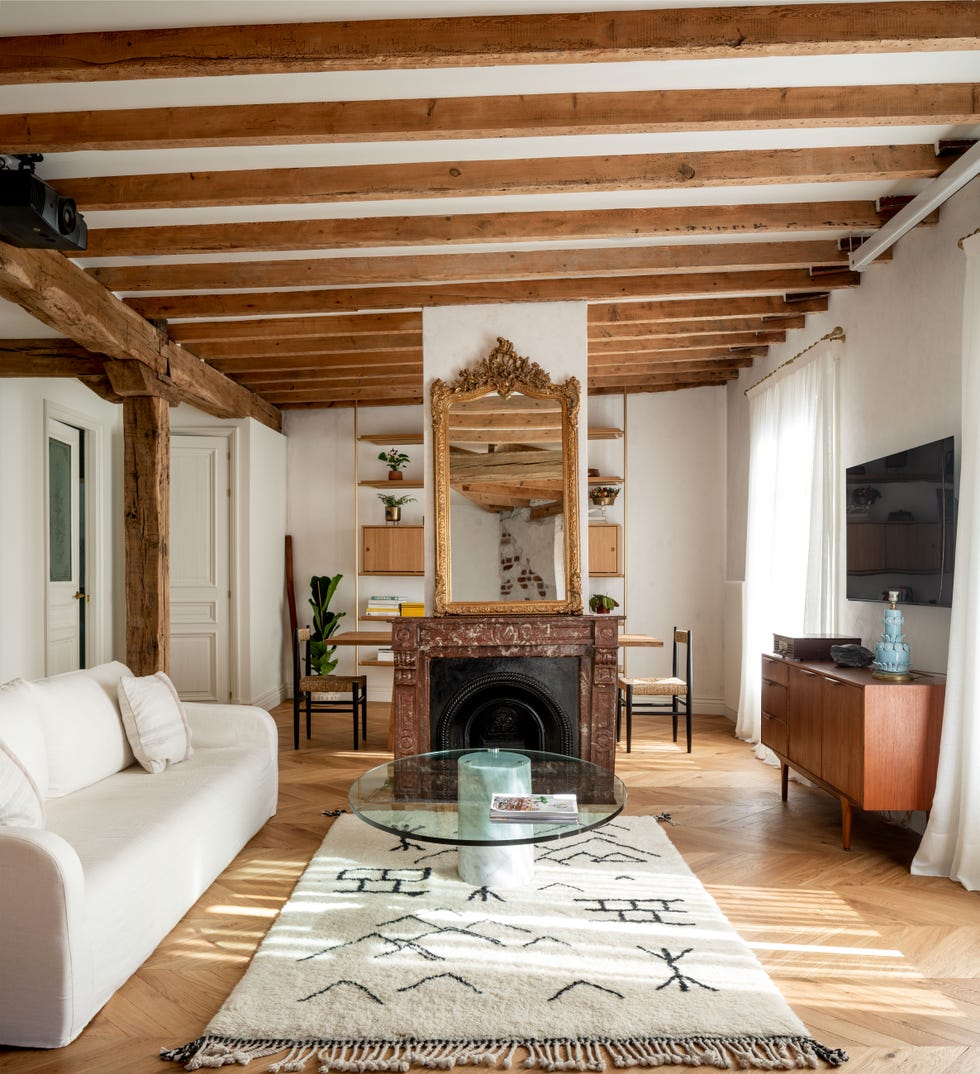 salón comedor con vigas vistas de madera y chimenea de mármol