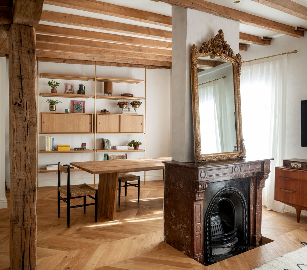 salón comedor con vigas vistas de madera y chimenea de mármol