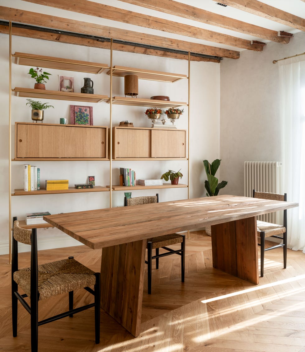 comedor con mesa de madera, sillas de fibras y estantería con diseño mid century