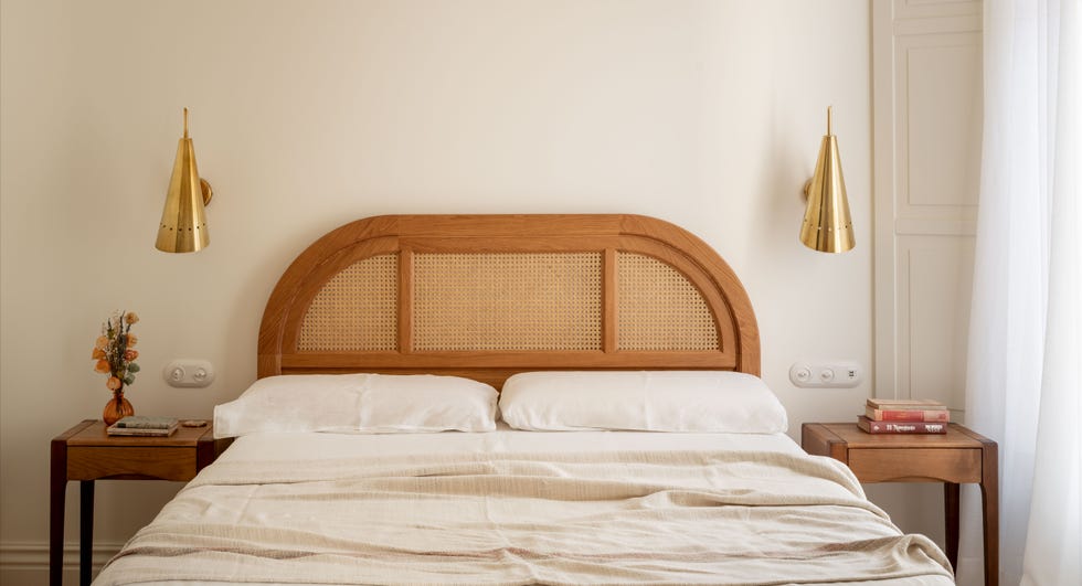 cama con cabecero de rejilla de ratán y apliques dorados