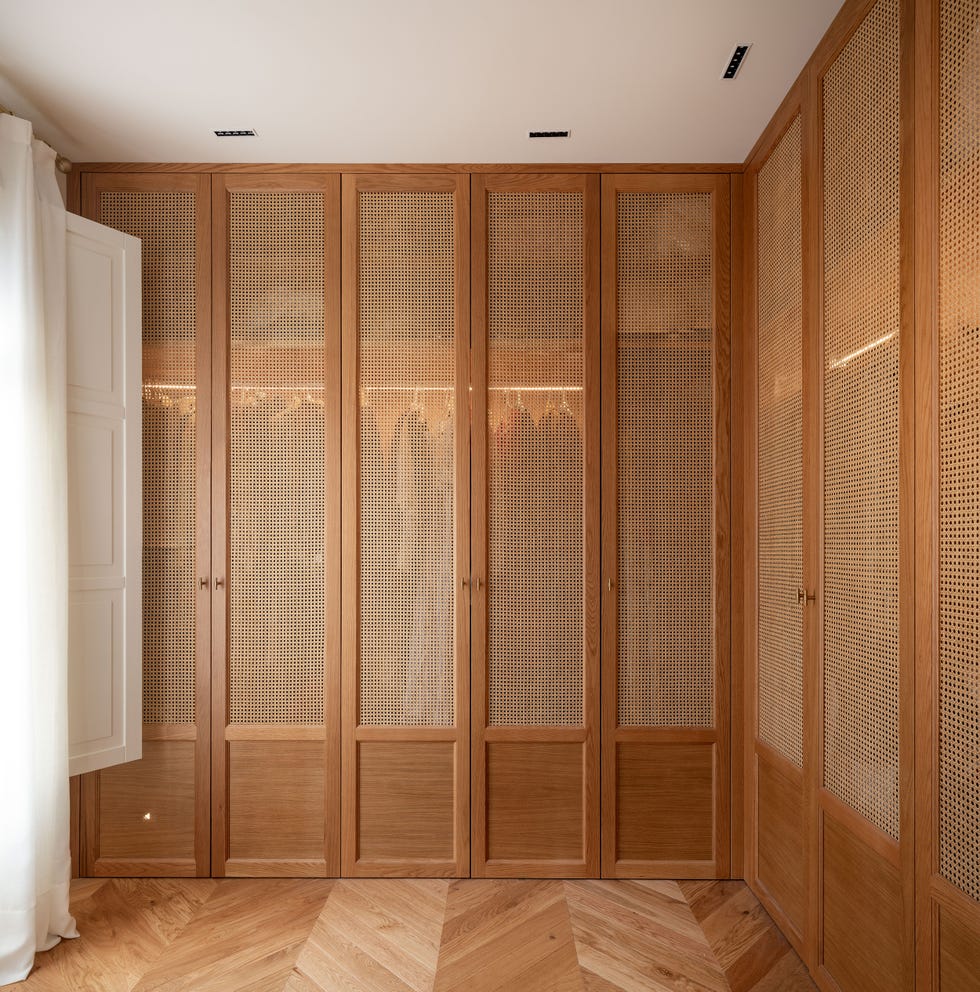 vestidor en l con armarios de madera y puertas de rejilla