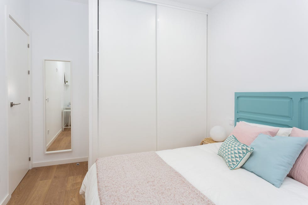 dormitorio con armario blanco con puertas correderas