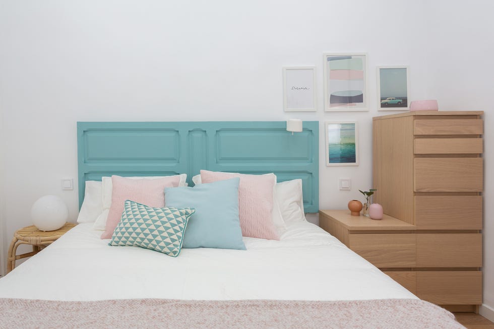 dormitorio con escritorio y puerta antigua pintada de azul como cabecero
