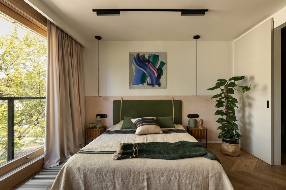 dormitorio con cabecero de terciopelo verde y puertas correderas con acceso a la terraza