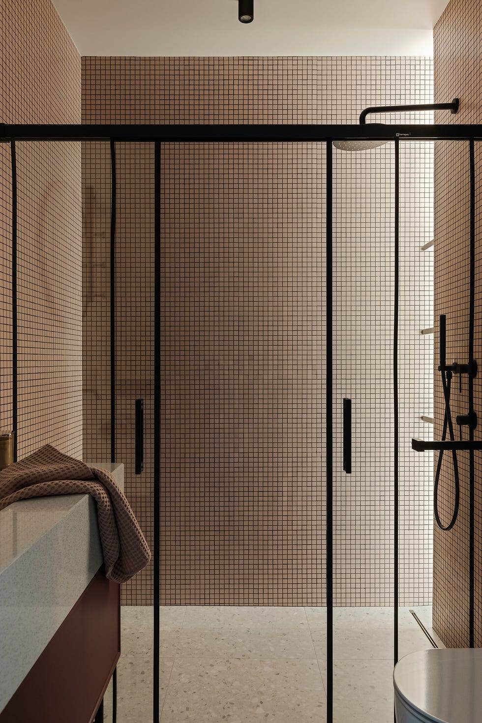 ducha revestida con azulejos rosas cuadrados