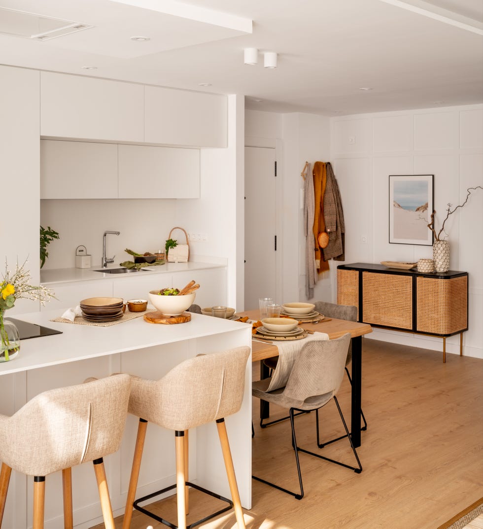 cocina abierta moderna en color blanco con isla y mesa de comedor anexa