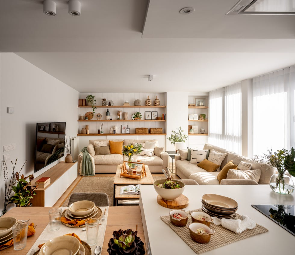 salón moderno con dos sofás de color beige, mesas de centro tipo nido y pared con tres estantes de madera