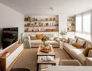salón moderno con dos sofás de color beige, mesas de centro tipo nido y pared con tres estantes de madera