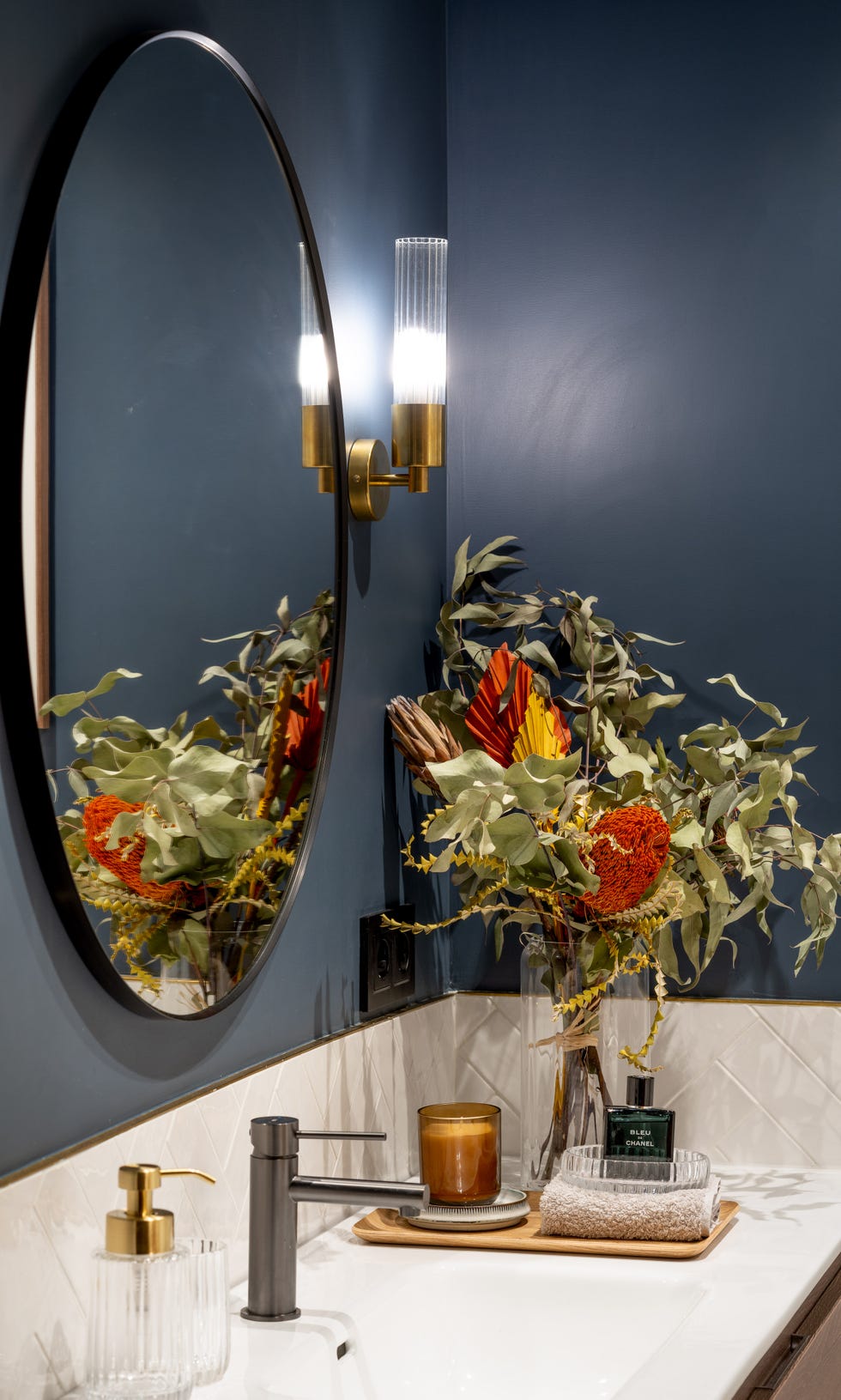 baño moderno con la pared pintada en azul oscuro y azulejos blancos en espiga