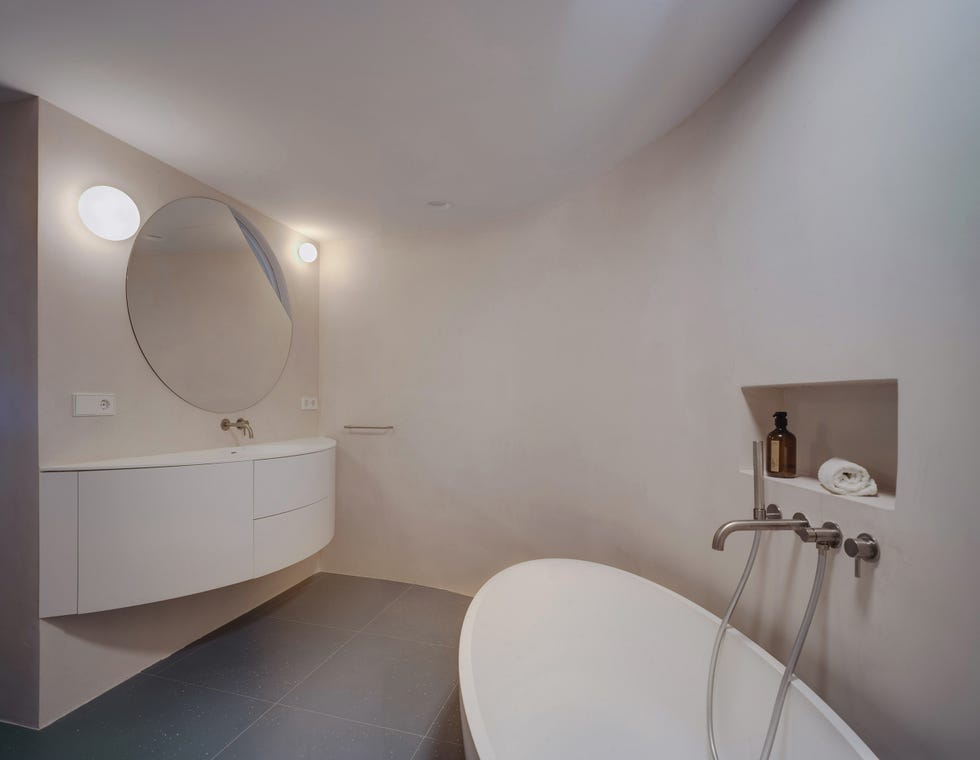 baño moderno con bañera exenta y mueble curvo en color blanco
